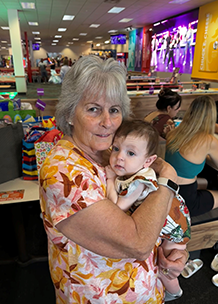 Grandma holding baby Rowan at the August Birthday Crew's Chucky Cheese Party - Thumbnail